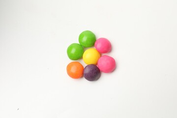 Many delicious colorful candies isolated on white, top view