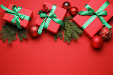 Wrapped Christmas gifts and decor on red background, flat lay. Space for text