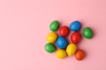 Obraz premium Delicious colorful candies on pink background, flat lay. Space for text
