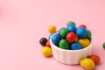 Delicious colorful candies in bowl on pink background, closeup. Space for text
