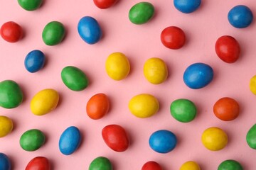 Delicious colorful candies on pink background, flat lay