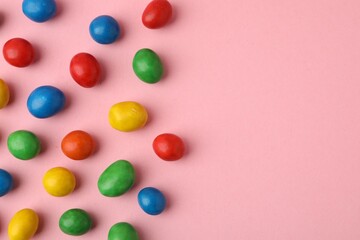 Delicious colorful candies on pink background, flat lay. Space for text