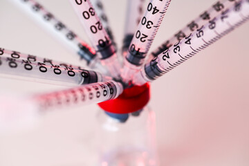 Close up of Single Use Syringes Inserted Into Glass Vial's Rubber Lid