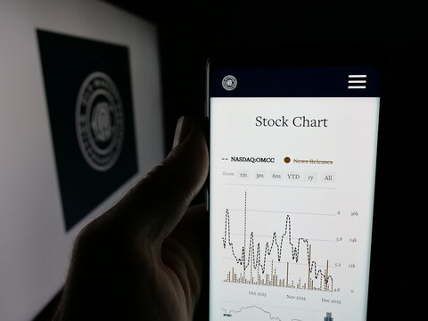 Stuttgart, Germany - 12-02-2025: Person holding smartphone with web page of company Old Market Capital Corporation on screen in front of logo. Focus on center of phone display.