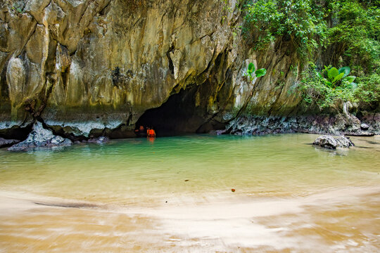 Tourists swimming into the mysterious Emerald Cave known as Tham Morakot, a hidden beach paradise accessible by an emerald lagoon on Ko Muk island in Trang, Thailand