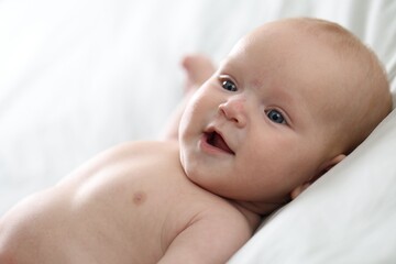 Cute newborn baby lying on bed indoors