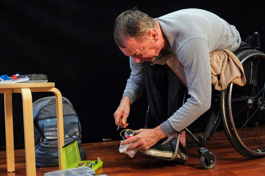 A man in a wheelchair repairs a spinning reel