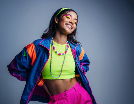 Młoda kobieta ubrana w neonowe, stylowe ubrania pozuje do zdjęcia