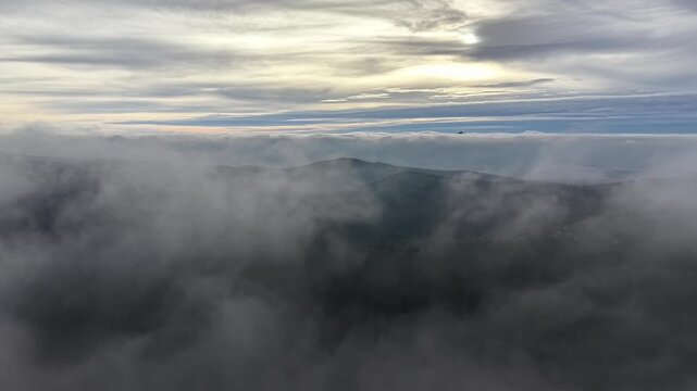 Mountain Ridges Wrapped In Cool Fog Under Diffuse Light, Aerial Sweep Reveals Layered Peaks And Quiet Valleys
