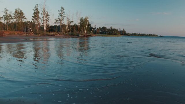 Lake with gentle calm waves during sunset