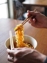 Steaming Ramen Noodles Being Lifted with Chopsticks