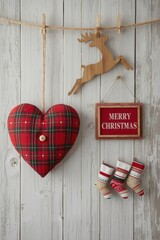 A Christmas holiday arrangement featuring a red plaid heart pillow, a small wooden reindeer cutout, a framed "MERRY CHRISTMAS" sign, and three miniature hanging stockings, all set against a rustic whi