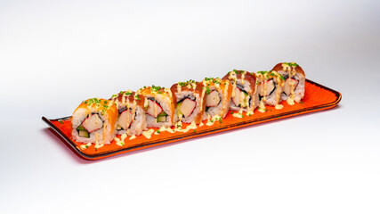 Platter of sushi rolls, likely Tiger Roll or Ebi Roll, served on an orange rectangular plate,...