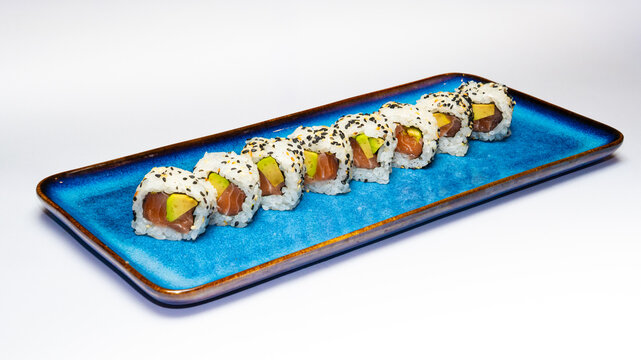 Plate of California rolls, a popular uramaki or inside-out sushi roll, photographed on a white background, perfect for Japanese cuisine menus, food photography, and restaurant promotions. - Powered by Adobe