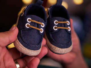 Blue baby shoes held toward the camera
