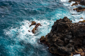 Turquoise Atlantic waves crashing against dark volcanic rocks on the wild north coast of Tenerife.