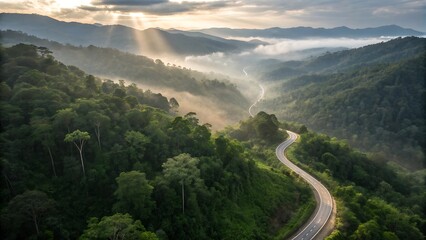 High-altitude cinematic shot of a serpentine mountain road cutting through an emerald tropical rainforest, early morning fog drifting between treetops, dramatic light rays piercing the mist, untouched