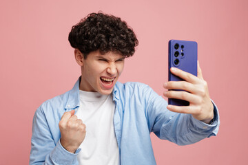 Excited teenager taking selfie with smartphone celebrating success