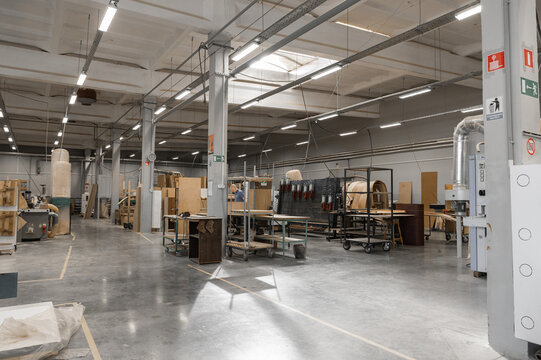 A woodworking shop displays various lumber and machinery in a bright, industrial space. Concept of craftsmanship, manufacturing