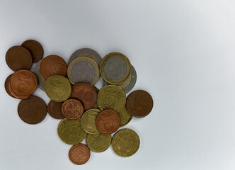 Pile of euro coins of different denominations scattered on a white background. Concept of money, finance,