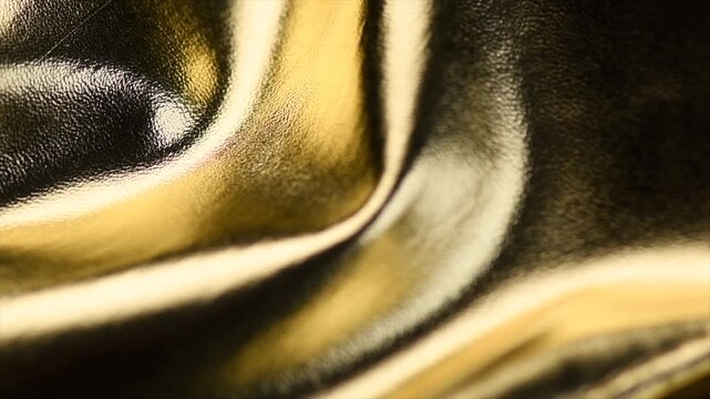 Golden leather texture background, glossy gold leather skin backdrop rotating, fashion. Slow motion