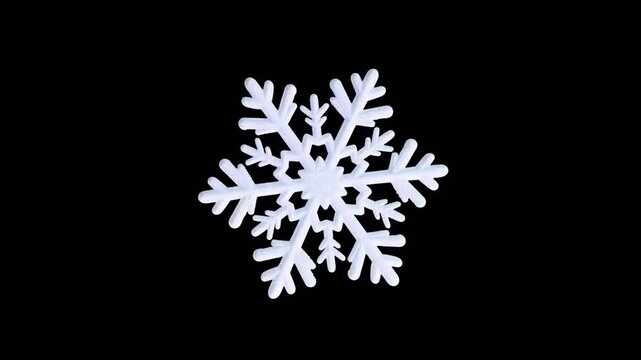 Decorative white frosted snowflake with intricate pattern appearing and disappearing while smoothly rotating around its axis on a pure black background, perfect for Christmas and winter holiday