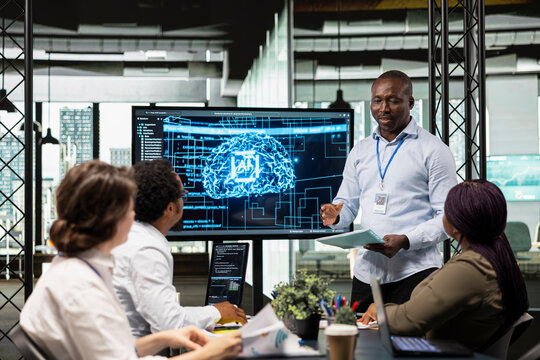 Manager and IT employees collaborate on implementation of AI solutions to increase productivity in business sector. Team leader and engineers discussing software development roadmap in startup office