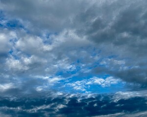 Wolkengebilde in unterschiedlichen Farbt&ouml;nen vor blauem Himmel