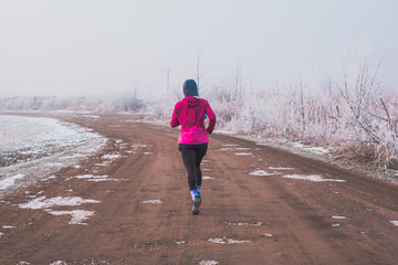 woman jogging on a gravel path in winter