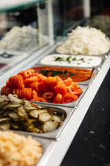 Pickled cucumber, carrot, onion, and fermented sauce are stored in separate containers, offering tangy, preserved ingredients ready for serving or cooking.