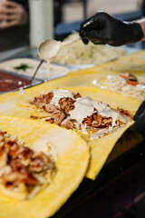 Several freshly cooked kebabs are shown as sauce is being poured over them, highlighting their juicy texture and rich, flavorful presentation.