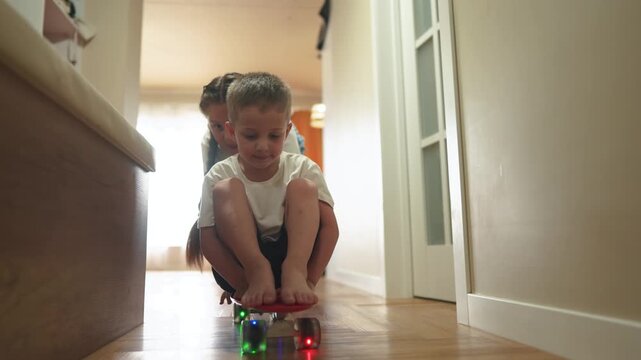Group of children playing on a skateboard indoors. Kid happy family child concept. group of kids are learning how to skateboard and it is funny. Children learning how to fun skateboard in indoors.