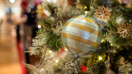 Bright and shiny Christmas toys are hanging on the Christmas tree.