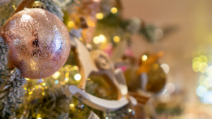 Bright and shiny Christmas toys are hanging on the Christmas tree.