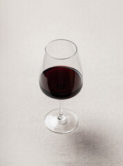 Glass of red wine on soft neutral fabric