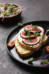 Slices of white bread with young cream cheese, freshly sliced figs and radish sprouts.