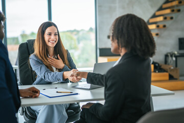 Businesswoman shaking hands with client during meeting in office
