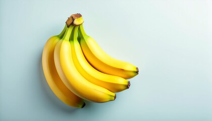 High Angle View of a Bunch of Five Perfectly Ripe Yellow Bananas Resting on a Soft Light Blue Background