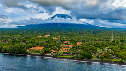 Scenic view of the lush Bali coast and Mount Agung under a dramatic cloudy sky