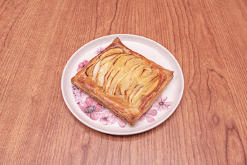 Puff pastry filled with apple and cinnamon compote, shaped into a sealed triangle, with a sugar and cinnamon glaze that forms a shiny, crisp crust