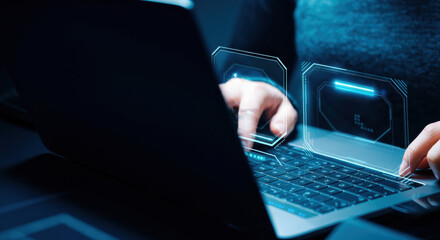 Person typing on laptop with holographic cybersecurity interface and data icons