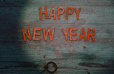 Buchstaben mit der Schrift Happy New Year mit Glitzer auf einem alten Holzuntergrund