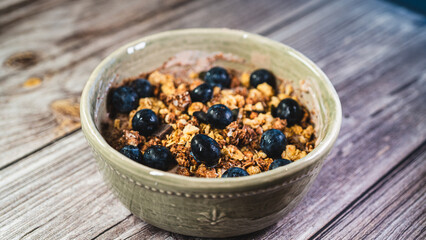 Healthy yogurt bowl with whey protein, crunchy granola, chocolate chunks, and fresh blueberries. Nutritious, protein-packed breakfast or snack for fitness and wellness lifestyles.