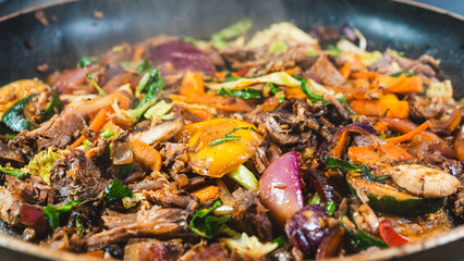 Shredded lamb cooking with mixed vegetables in a frying pan, tender and melting together. Savory, hearty, and perfect for a comforting meal or filling for wraps and bowls.