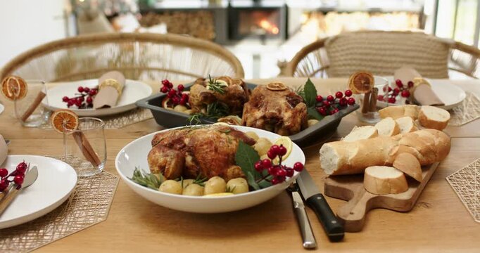 Camera is tilting upward from roast chicken bowl to reveal stove and Christmas tree, showing table