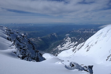 Tranquil Lake With Lush Green Forest, Snow-Capped Mountain, Blue Sky And White Clouds
