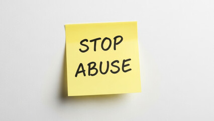 Stop abuse sticky note on white wall conveying important message about ending mistreatment and promoting awareness. Visual reminder emphasizes need to address and combat abuse in all forms.