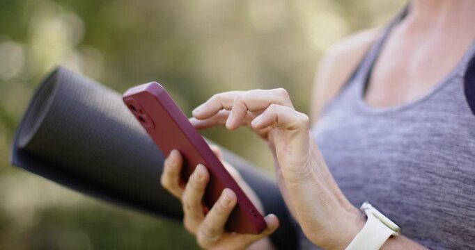 Woman swiping phone unlocking screen, scrolling and selecting yoga session before lowering phone