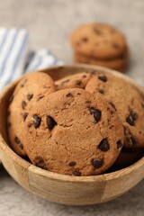 Delicious chocolate chip cookies in bowl on table, closeup
