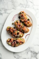 Delicious bruschettas with salmon, avocado, capers, onion and sauce on white marble table, top view